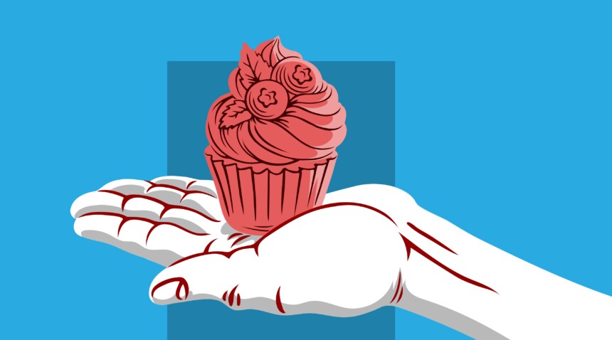 Hand holding out a cupcake.