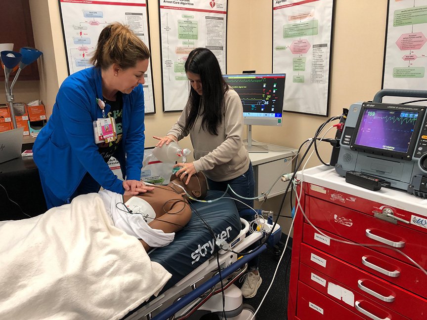Two nurses practice CPR on new manikins