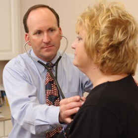 Doctor listens to patients heart.