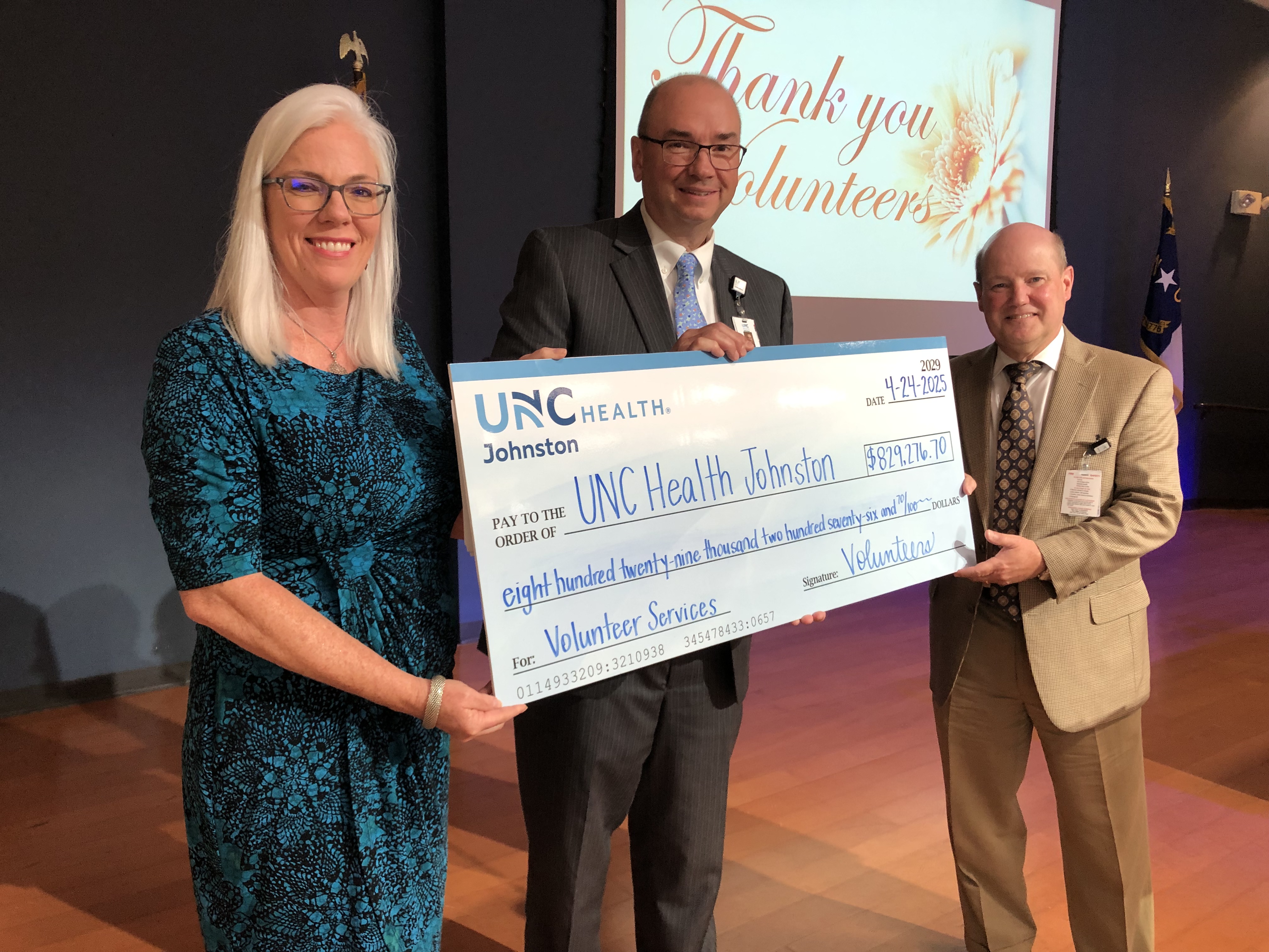 April Culver, Tommy Williams and David Mills present the volunteer hours check