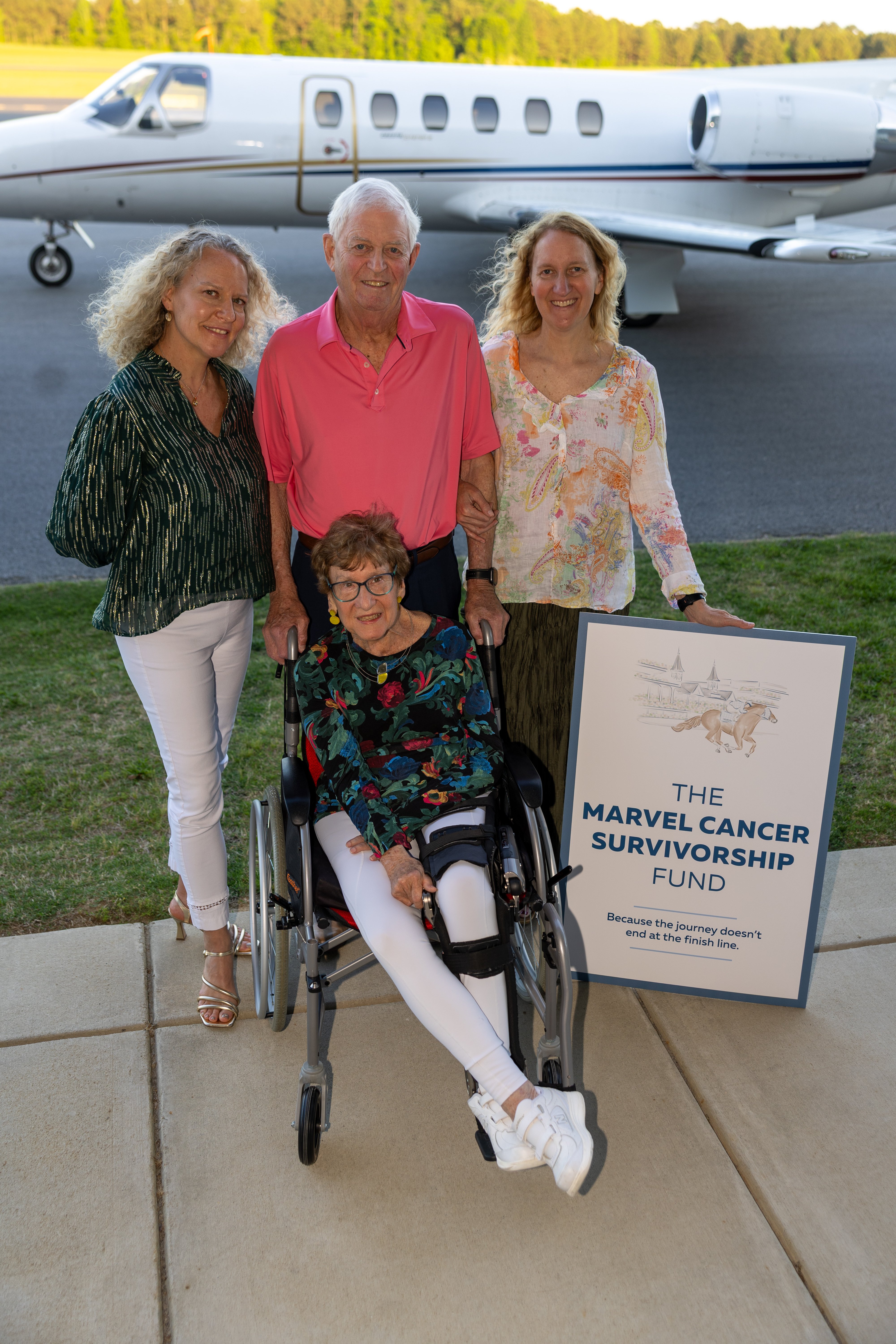 The Marvel family standing in front of small jet.