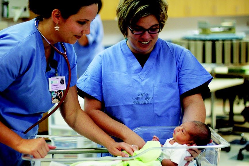 Nurses with baby in the Women's Pavilion